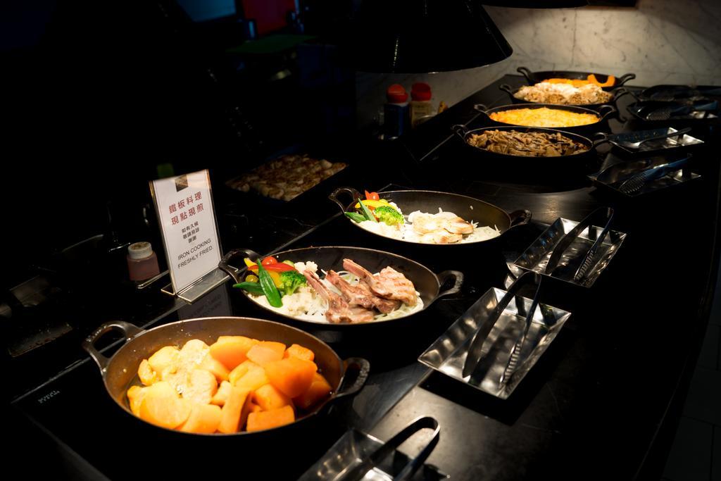 Ambassador Hotel Καοσιούνγκ Εξωτερικό φωτογραφία The photo shows a buffet-style food display featuring several dishes in oval serving pots. There are a variety of cooked vegetables and meats, with one pot containing a mix of root vegetables or squash, another with meat and vegetables, and possibly 