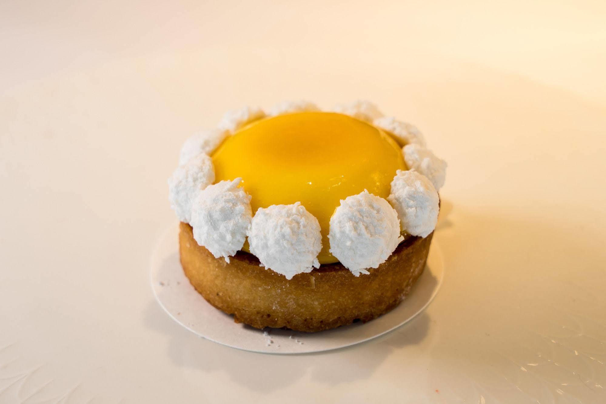 Ambassador Hotel Καοσιούνγκ Εξωτερικό φωτογραφία The photo showcases a round dessert, likely a tart or mini cake. The base appears to be a golden-brown, crumbly crust. It is topped with a bright yellow custard or gel-like layer, which gives it a vibrant appearance. Surrounding the yellow center is 